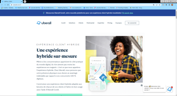 Smiling woman in plaid shirt holding a smartphone with Uberall CoreX hybrid experience text.