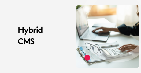 Hybrid CMS text beside a person working on a laptop and calculator at a desk.