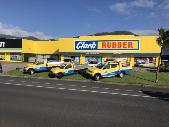 Clark Rubber storefront with yellow vehicles parked outside on a sunny day