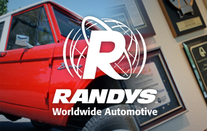 Randys Worldwide Automotive logo with red truck and awards on wall.