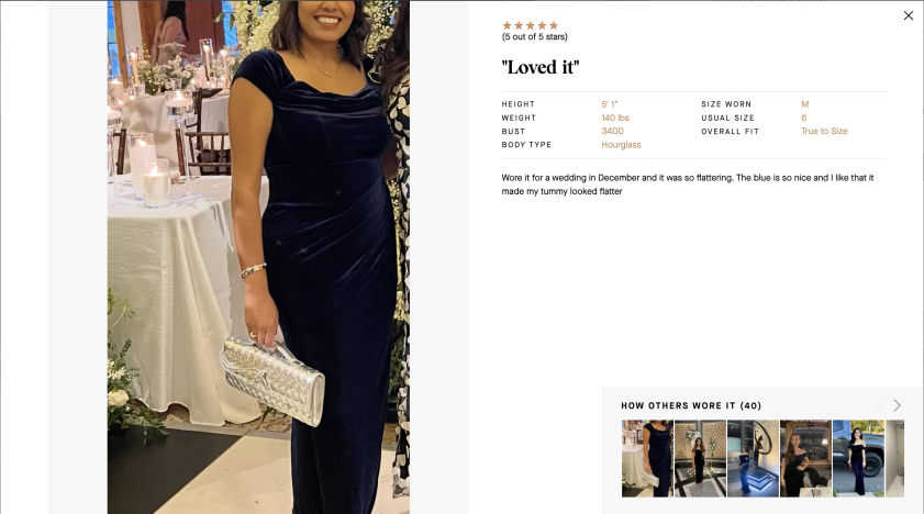 Woman in navy velvet gown holding silver clutch at a formal event.