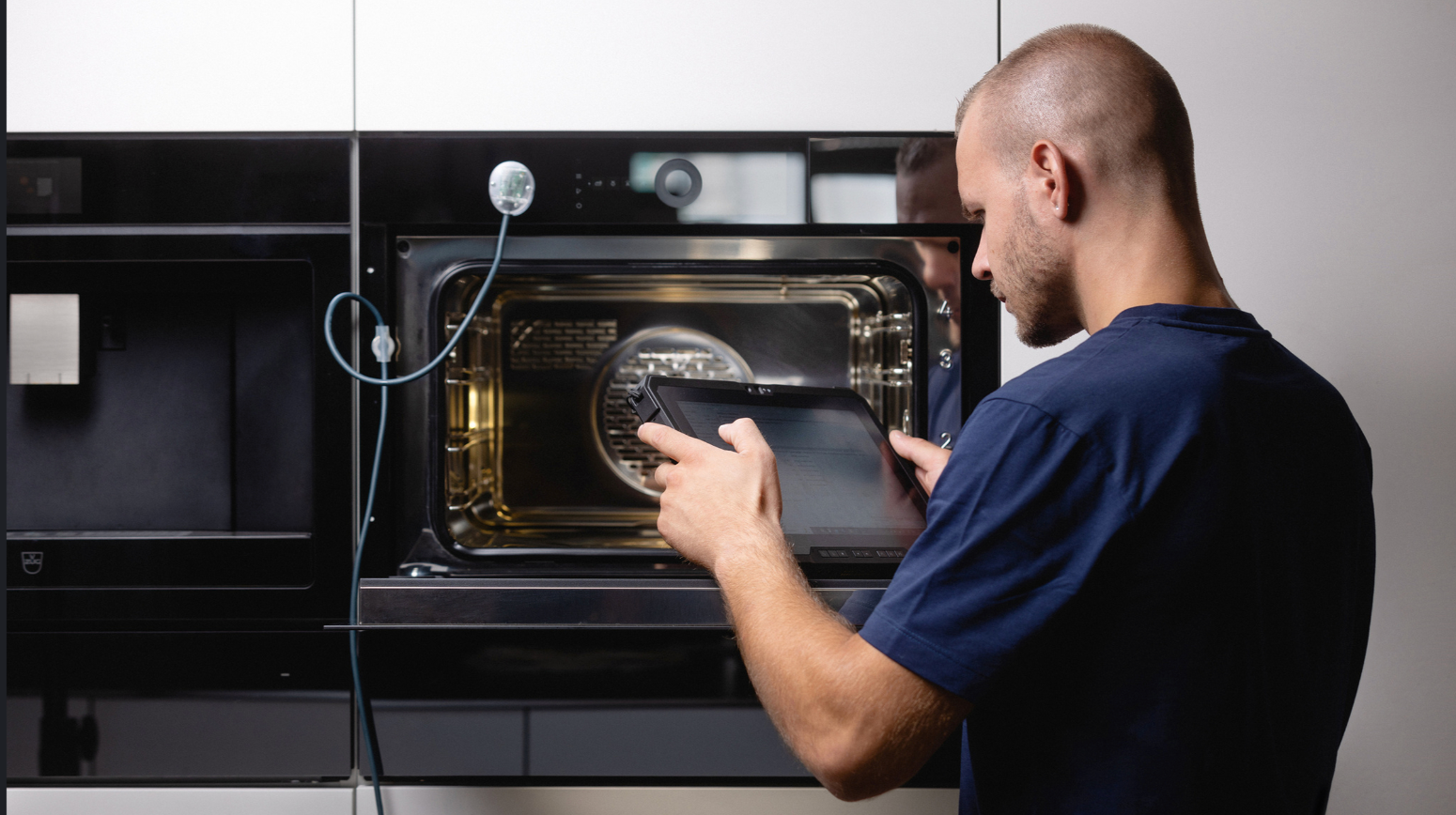 Technician using tablet to inspect oven functionality