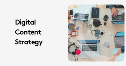 Overhead view of a digital content strategy meeting with laptops and devices on a wooden table.