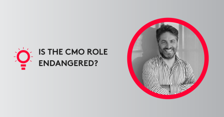 Portrait of a smiling man in a striped shirt with text 'Is the CMO role endangered?' on a gray background.
