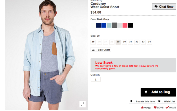 Man wearing light blue shirt and dark grey corduroy shorts with price details.