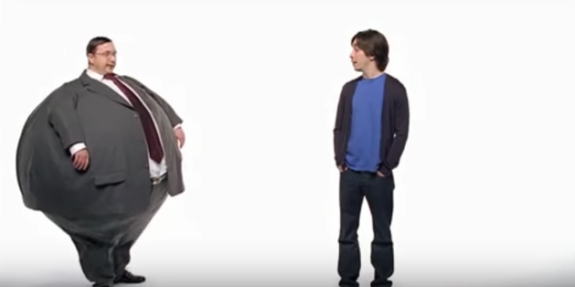 Two men conversing, one in a suit and the other casually dressed, on a white background.