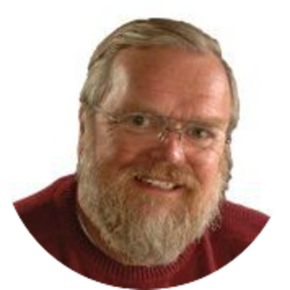 Man with glasses wearing a red sweater, smiling against white background.