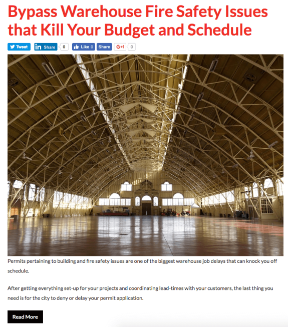 Interior view of a large empty warehouse with truss ceiling and polished floor.