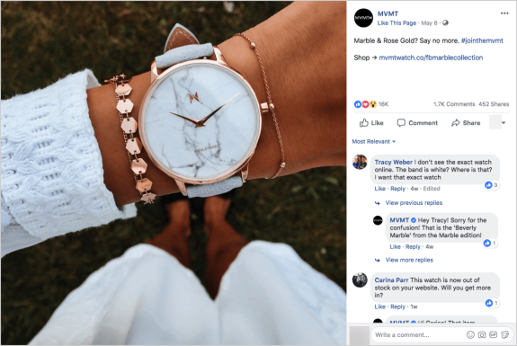 Close-up of a wrist wearing a marble face rose gold watch with a white sweater.