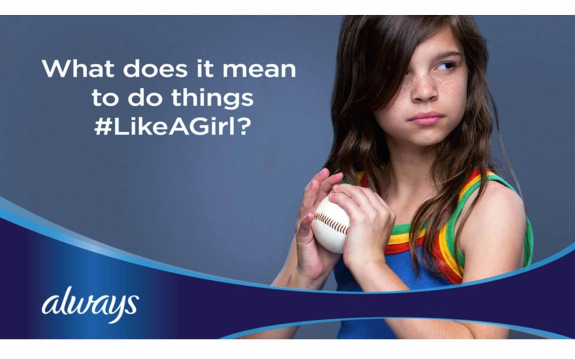 Young girl holding a baseball with #LikeAGirl campaign message
