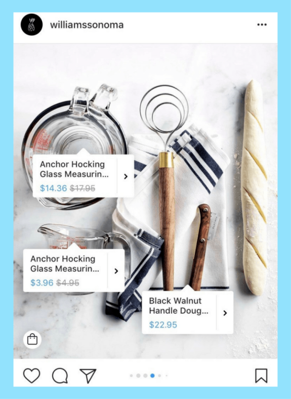 Kitchen tools including measuring cup, dough whisk, and bread on a cloth.