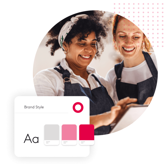 Two women in aprons smiling and looking at a tablet with a brand style guide.