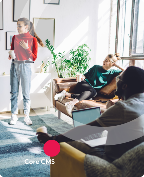 Colleagues having a casual meeting in a bright office with coffee and laptops.