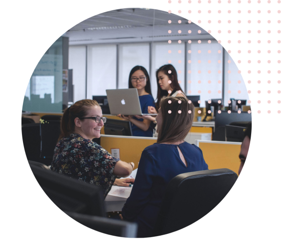 Team collaborating in a modern office with laptops and discussions.