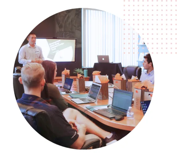 People in a conference room attending a business meeting with laptops.