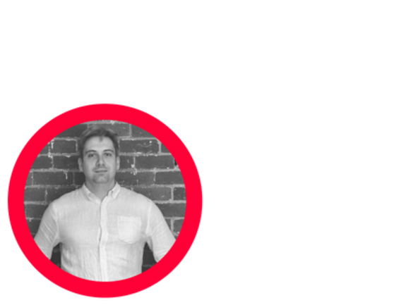 Man in white shirt standing against a brick wall with a red circle overlay.